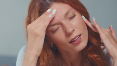 caucasian woman suffers from health problems touches head with eyes closed