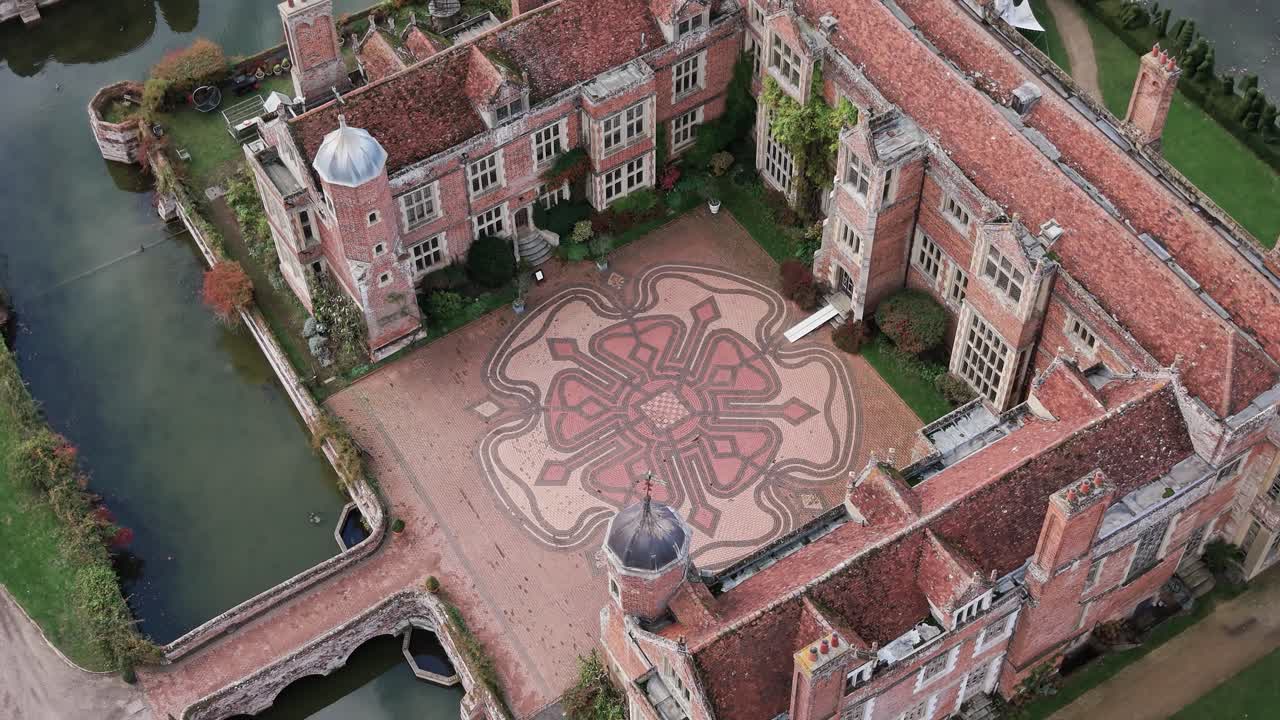 Kentwell hall aerial Birdseye view circling mansion Tudor rose mosaic courtyard and moat in Suffolk