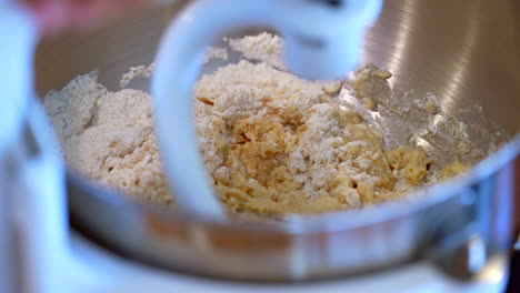 mezclar ingredientes en una batidora de pie profesional con un gancho de masa - cámara lenta aislada