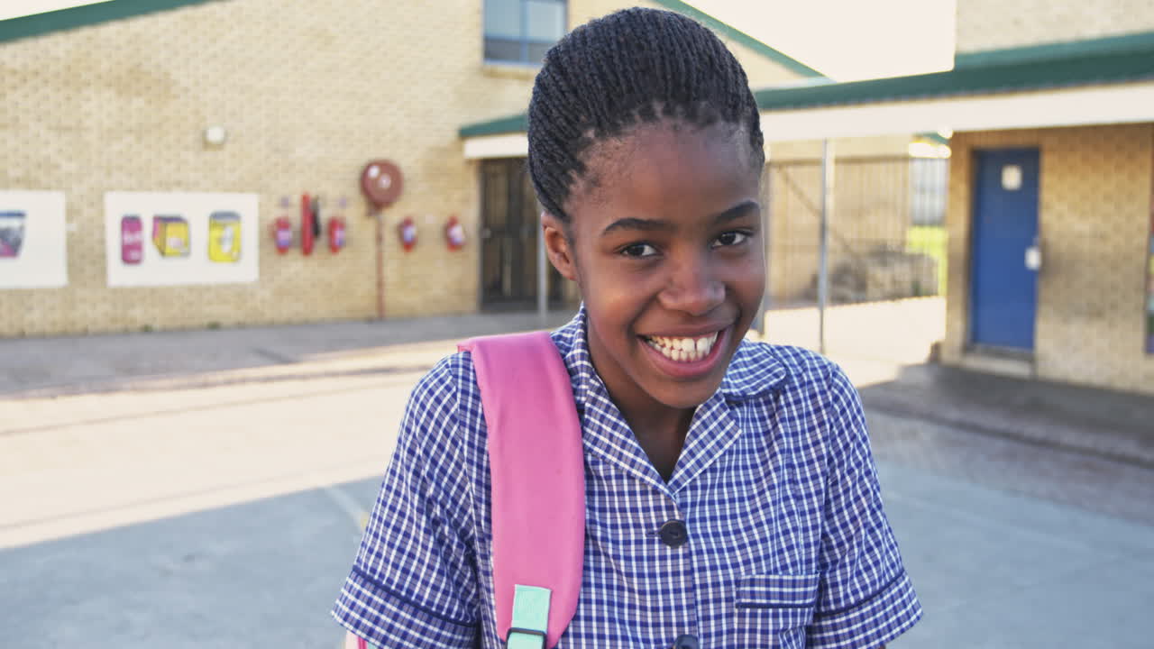Portrait of a young schoolgirl smiling in playground 4k
