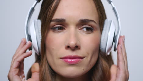 business woman putting on headphones in studio.girl listening music in earphones