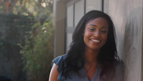 Retrato-De-Una-Mujer-Afroamericana-Sonriente-En-El-Jardín-De-Casa-Contra-El-Sol-Abrasador