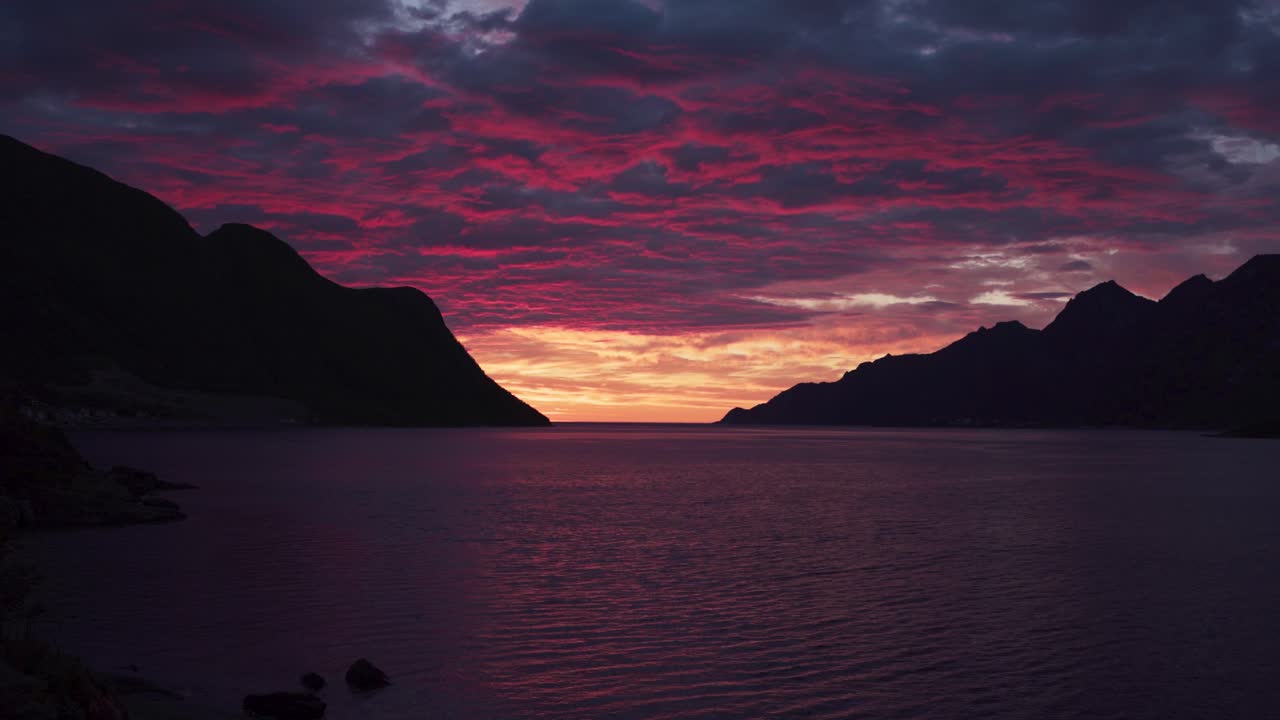 Pôr do sol dramático sobre as montanhas perto da vila de pescadores Fjordgard em Senja, Condado de Troms og Finnmark, Noruega.