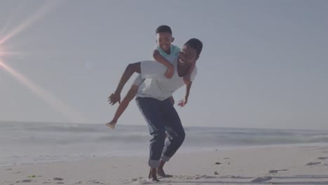 animación de rastros de luz sobre un hombre afroamericano y su hijo jugando juntos en la playa