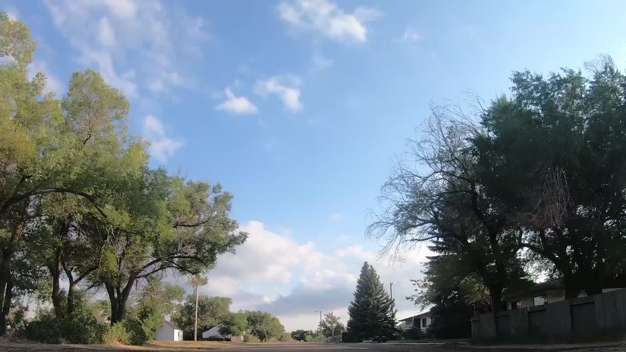 TIMELAPSE -In the middle of an empty street in a small town called Empress Alberta Canada on a sunny day with trees and buildings around