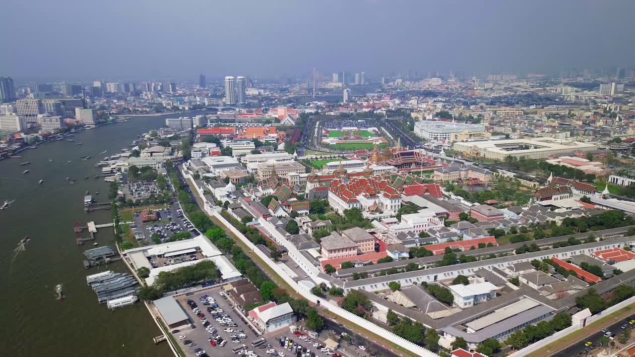 Aerial establishing overview of the Grand Palace in Bangkok, Thailand, golden rooftops, intricate temples, and courtyards