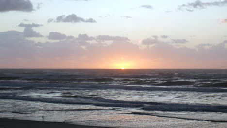 Männliche-Silhouette,-Die-Am-Strand-Steht-Und-Die-Wellen-Bei-Sonnenuntergang-Beobachtet