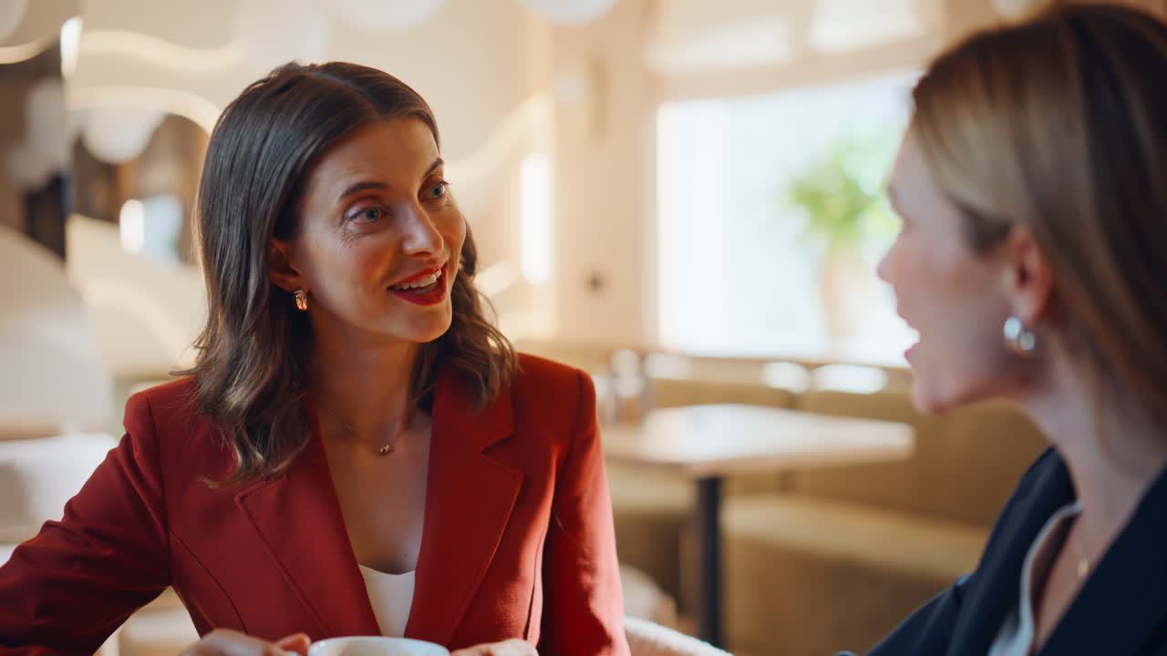 Elegant besties drinking coffee at friendly meeting in cafe closeup. Two women