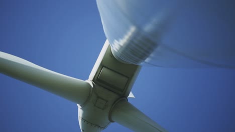 afternoon underneath perspective and standing footage from a wind turbine machine and its rotating blades