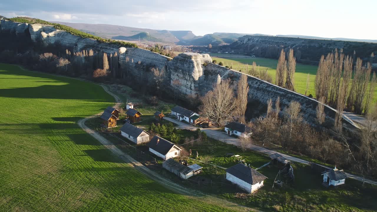 vista aérea de una aldea ubicada en un valle con un acantilado rocoso