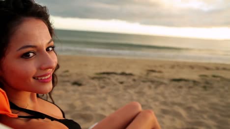 smiling brunette sitting on a deck chair relaxing