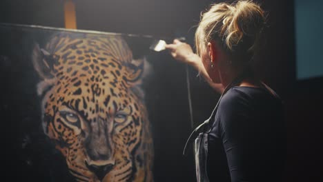woman painting a leopard portrait