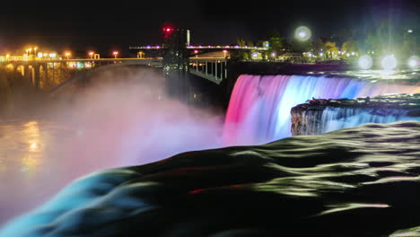 niagara falls at night with the glow of the city lights behind 3