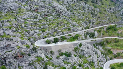 Carretera-Sinuosa-Del-Paso-De-Montaña-A-Través-De-Un-Paisaje-Rocoso-Verde