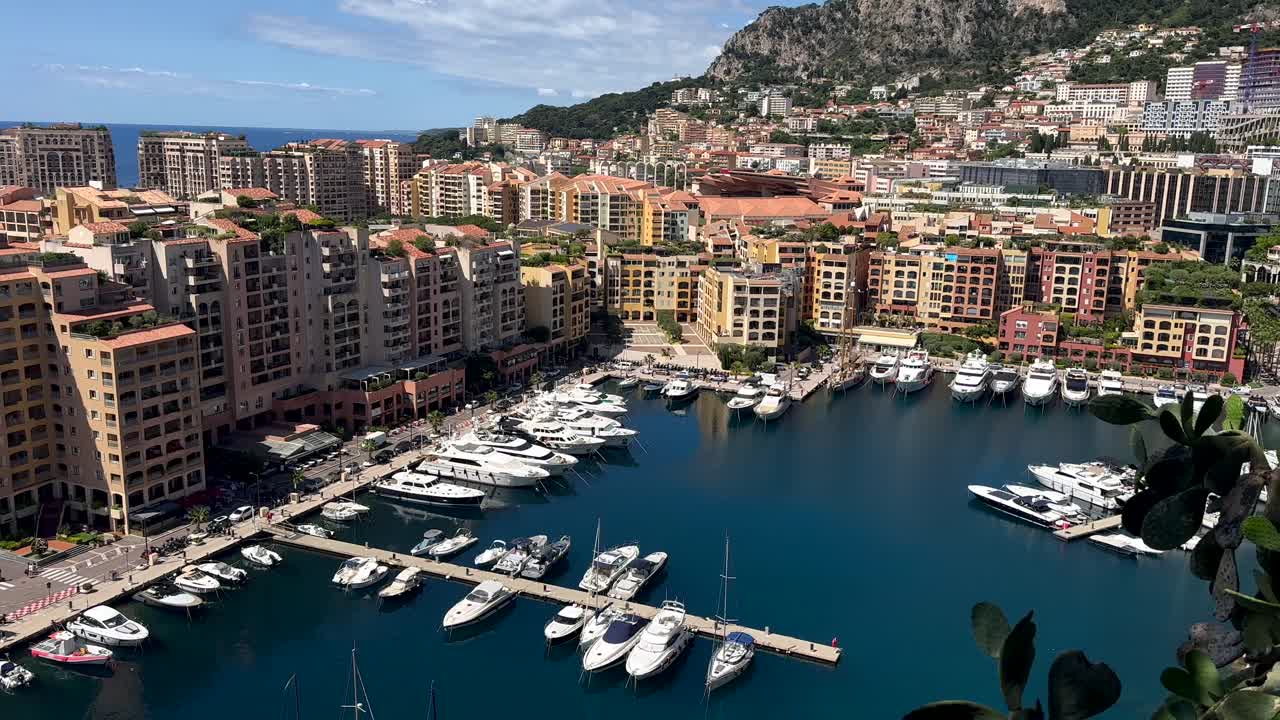 Panoramic drone shot of Fontvieille district of Monaco with marina and luxury yachts. Sunny day in summer season with upper class houses and neighborhood, France. Top down.