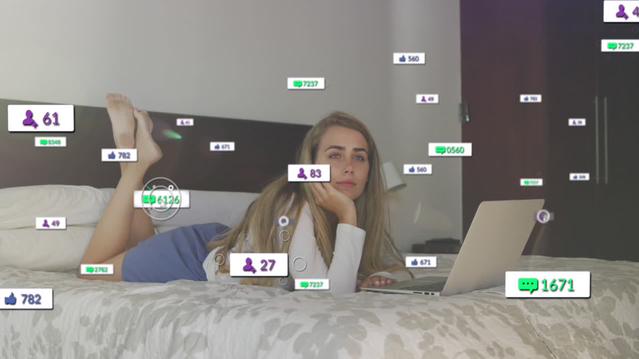 animación de los iconos de las redes sociales sobre la sonrisa relajándose en la cama usando una computadora portátil