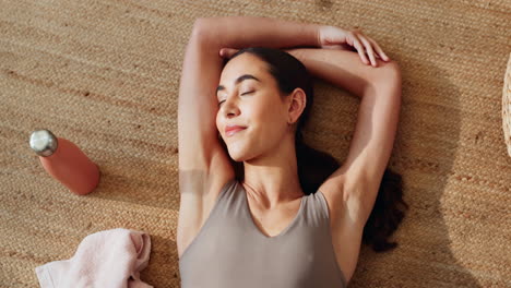 mujer estirándose y relajándose en una alfombra de yoga
