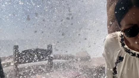 young woman is hilariously soaked by a huge rouge wave while on vacation