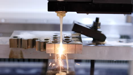 close-up of a wire electrical discharge machining (wedm) process on a metal workpiece, creating sparks during cutting