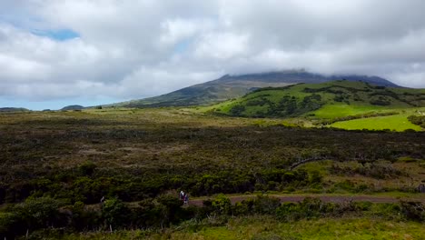 Aerial-shot-of-people-hiking-the-Mount-Pico,-going-on-the-dirt-road