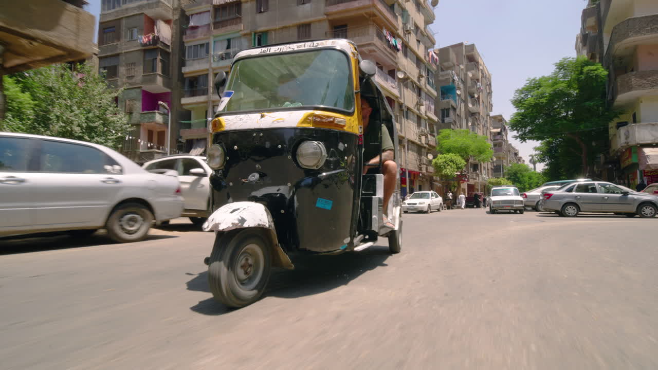 Tourists Strolling Around The Cairo City By Riding A Tuk Tuk In Egypt. - low level shot