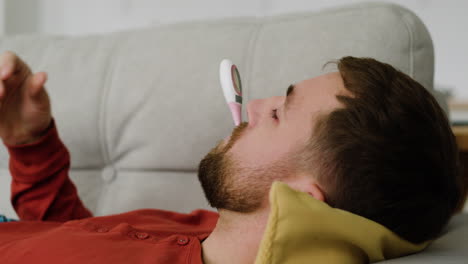 Sick-man-laying-on-the-sofa