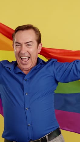 man celebrating with an lgbtq+ rainbow flag