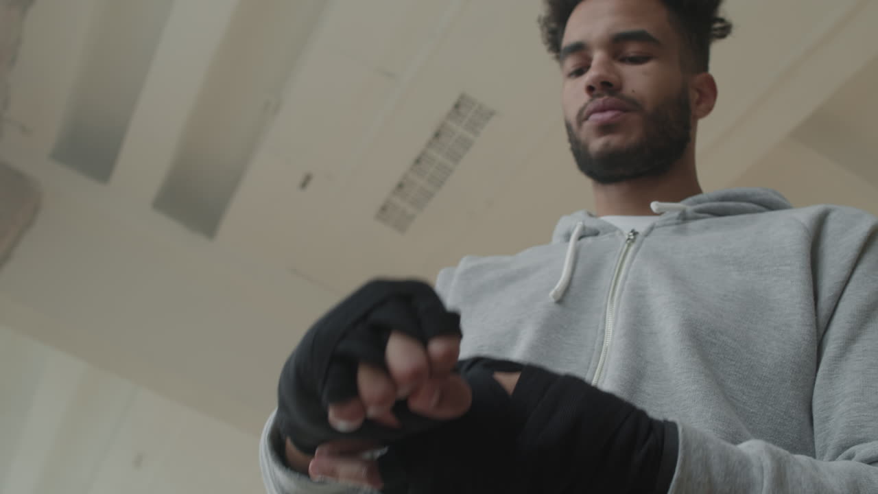 Black Sportsman Wrapping Hands Before Kickboxing