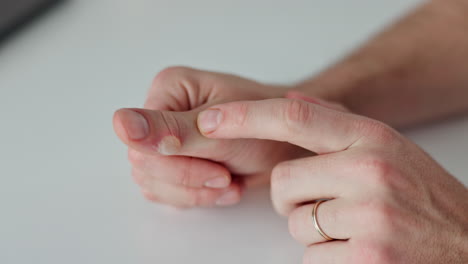 close-up view of a person examining a sore on their thumb