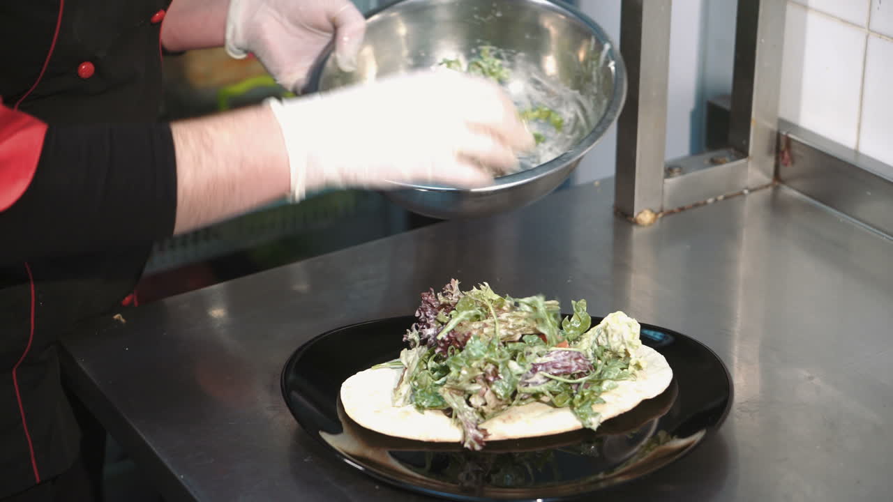 Chef cooking salad in a professional kitchen in a restaurant. Hands close up