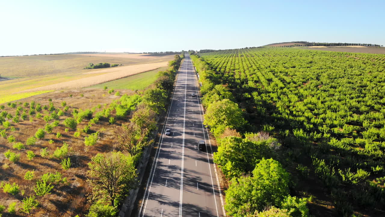 Aerial drone view of a road with moving car in highland. Green fields and hills from north part of Moldova