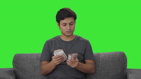 Indian-man-counting-money-at-home-Green-screen