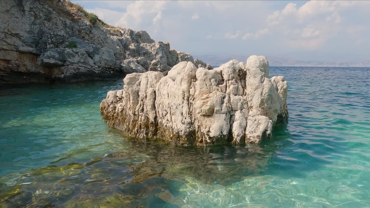 Vista di una roccia erosa situata al largo della spiaggia di Kassiopi in acque calme e turchesi