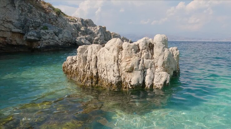 Vista di una roccia erosa situata al largo della spiaggia di Kassiopi in acque calme e turchesi