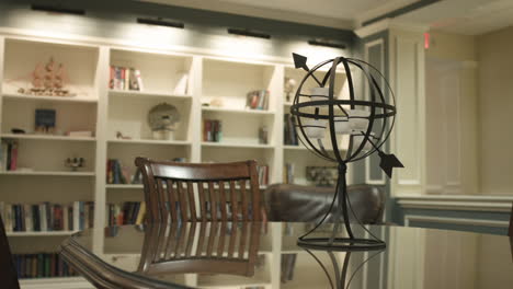 panning shot of styled decor in a library room with wood table and decorative objects