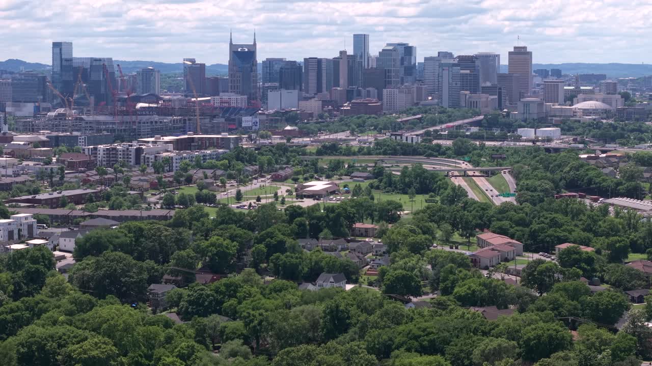 Urban cityscape of Nashville with expansive greenery and infrastructure from a high perspective. Aerial Rising Shot