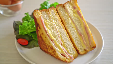 Sándwich de jamón y queso casero en la placa blanca.