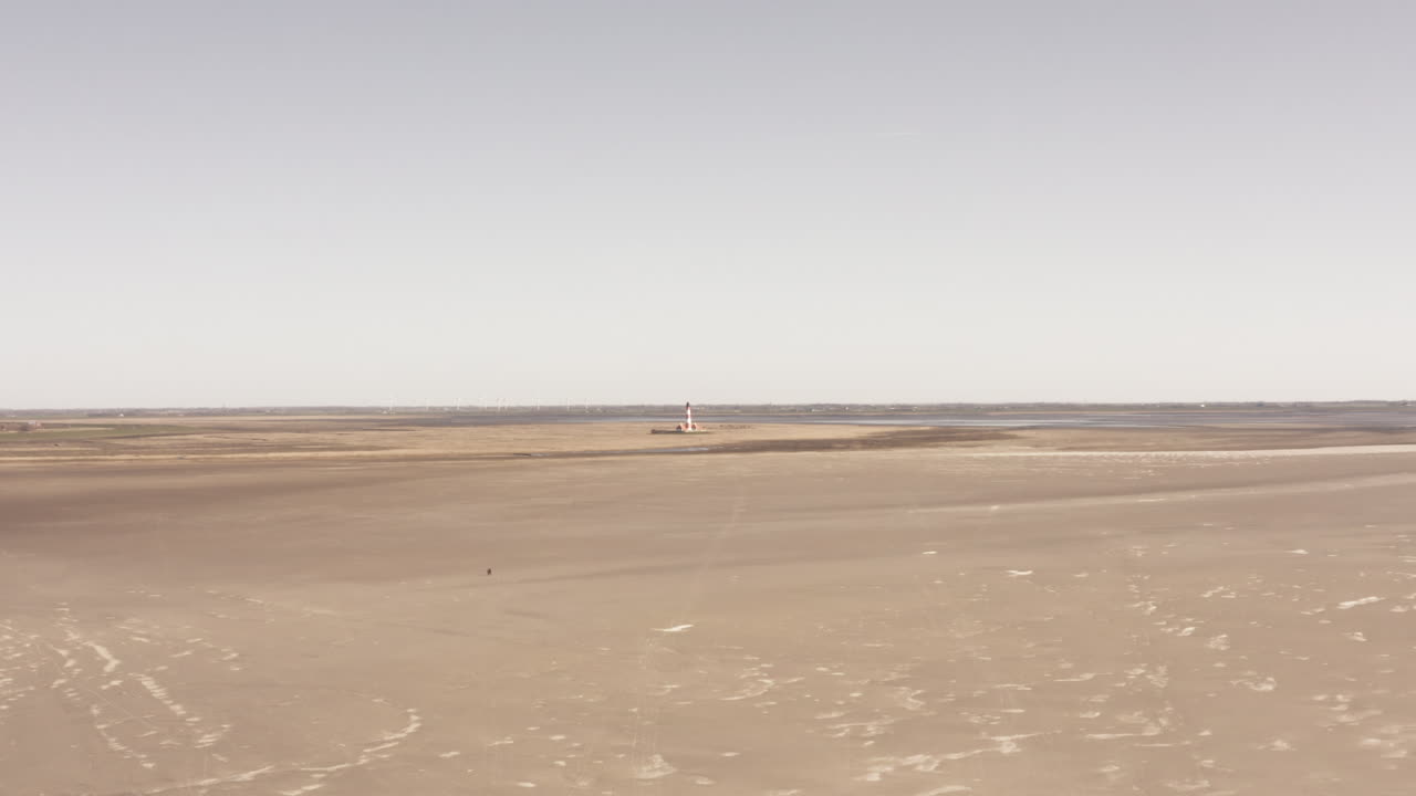 Expansive Tidal Flats with Distant Structure and Solitary Figure