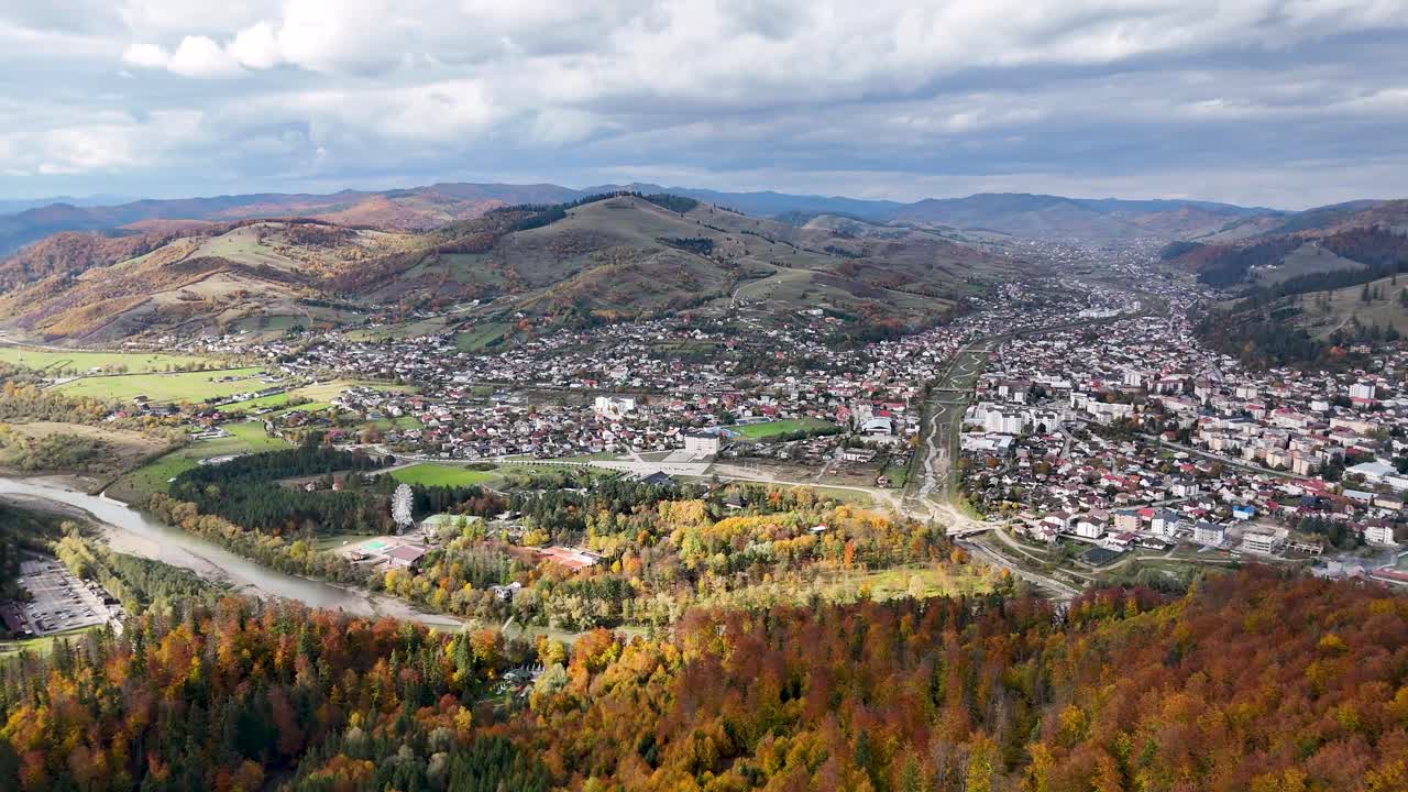 Gura Humorului kasabası ile sonbahar ormanları ve tepelerle çevrili Bukovina'daki Ariniș Parkı'nın drone çekim görüntüsü
