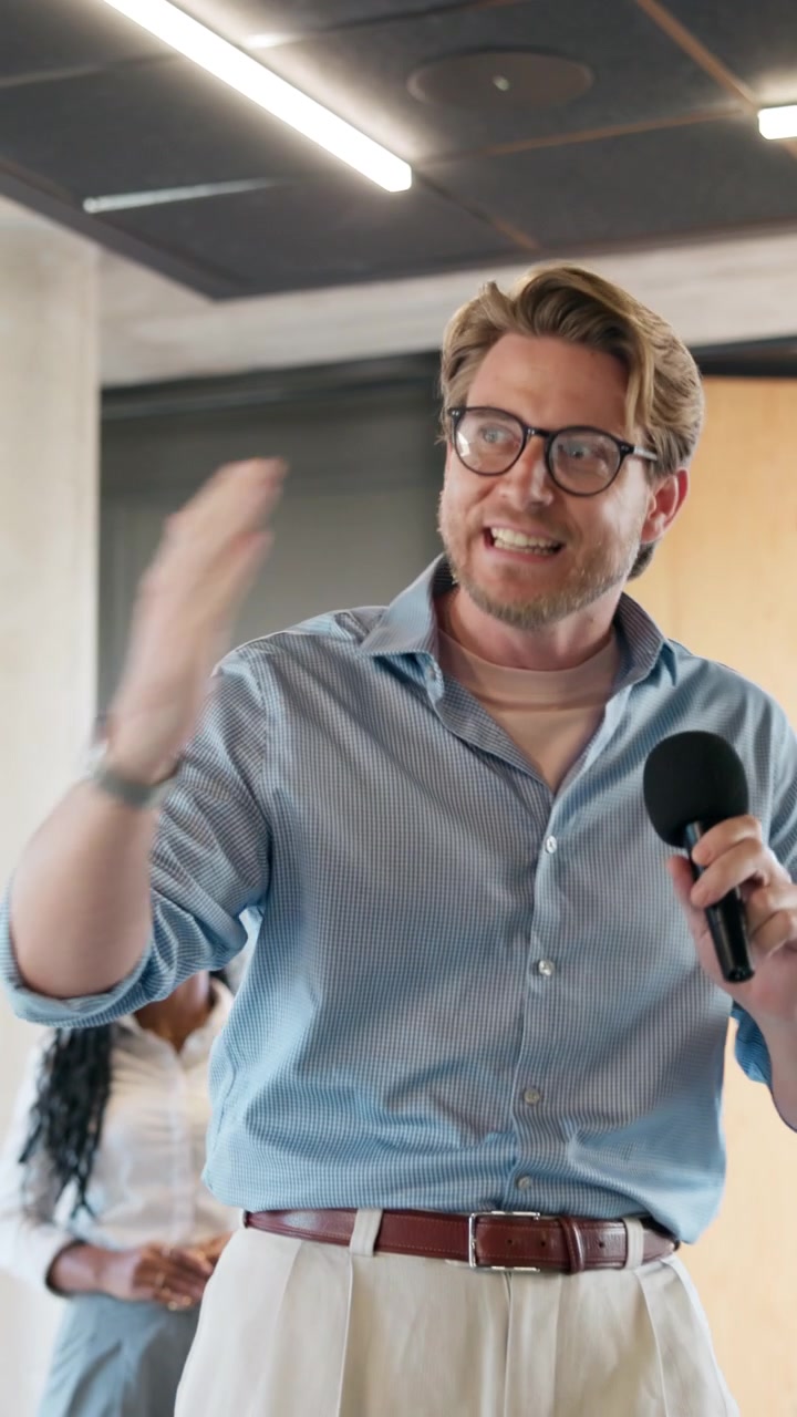 Uomo che tiene una presentazione con un microfono in ufficio
