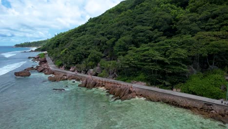 Aerial-View-of-road-along-rocky-coastline-on-La-Digue-Island-The-Seychelles