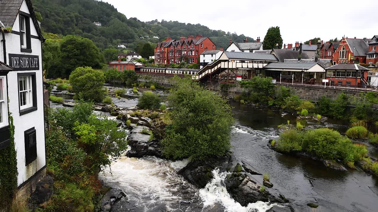 Fiume che scorre accanto a edifici storici e vegetazione