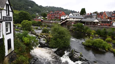 flowing river beside historic buildings and greenery