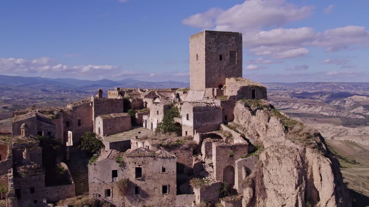 Città fantasma con figura solitaria sulla collina, Craco, Matera, Italia