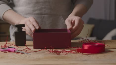 primer plano de hombre en casa regalo envolviendo romántico san valentín presente en caja 1