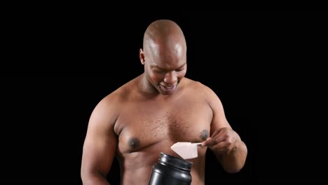 hombre musculoso sonriente con proteínas