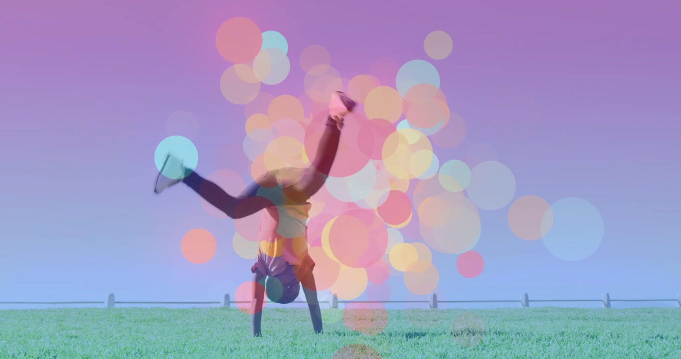 Boy planting hand, doing cartwheel across field, purple sky, bokeh pulsing during spin, training