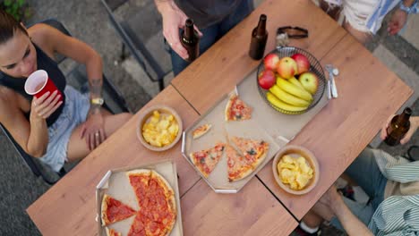amigos disfrutando de una pizza y cerveza juntos