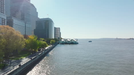 Forwards-fly-along-Hudson-river-waterfront-with-high-rise-office-buildings.-Heading-to-Brookfield-Place-ferry-terminal.-Manhattan,-New-York-City,-USA