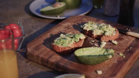 primer plano de tostadas de aguacate, verduras y jugo en la cocina, cámara lenta